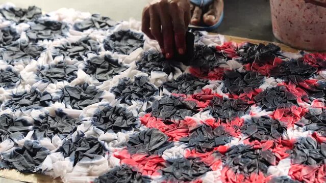 an Indonesian man dyeing clothes for batik