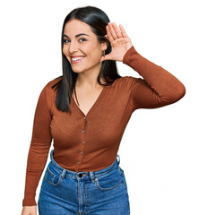 Fototapeta premium Young hispanic woman wearing casual clothes smiling with hand over ear listening an hearing to rumor or gossip. deafness concept.