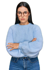 Young hispanic woman wearing casual clothes and glasses skeptic and nervous, disapproving...