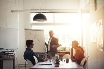 Late afternoon brainstorming in progress. Shot of a group of coworkers in a boardroom meeting.