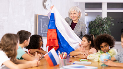 Obraz premium listening to teacher s story about Russia, child examines this country on globe