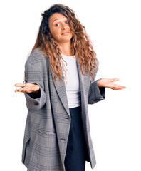 Young hispanic woman with tattoo wearing business oversize jacket clueless and confused expression...