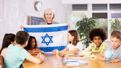 at entertaining geography lesson, children look at flag of Israel and listen to teacher s story...
