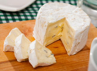 Image of tasty french cambozola cheese, slices at wooden desk..