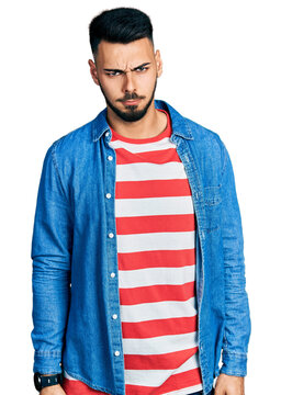 Young hispanic man with beard wearing casual denim jacket skeptic and nervous, frowning upset because of problem. negative person.