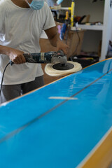 Man repairs surfboard, hands close up, Surfboard Workshop in Bali
