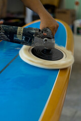 Man repairs surfboard, hands close up, Surfboard Workshop in Bali