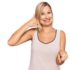 Middle age caucasian woman wearing casual clothes smiling doing talking on the telephone gesture...