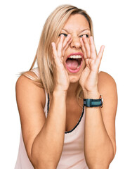 Middle age caucasian woman wearing casual clothes shouting angry out loud with hands over mouth