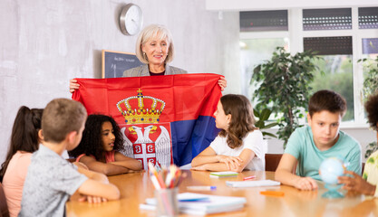 in geography lesson, elderly teacher very eloquently tells children about history of ancient Serbia