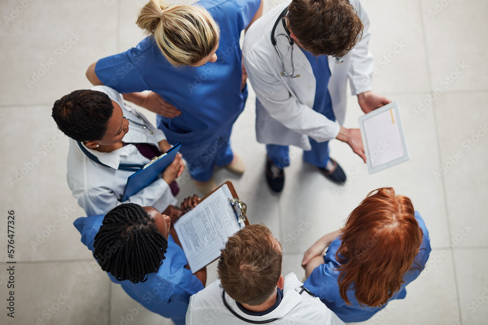 Sticker Monitoring the health of their patients. High angle shot of a group of medical practitioners working together in a hospital.