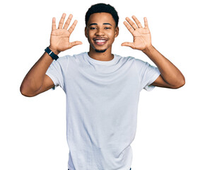 Fototapeta premium Young african american man wearing casual white t shirt showing and pointing up with fingers number ten while smiling confident and happy.