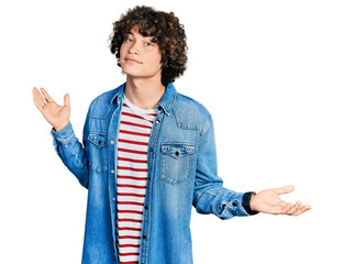 Caucasian teenager wearing casual clothes clueless and confused expression with arms and hands...