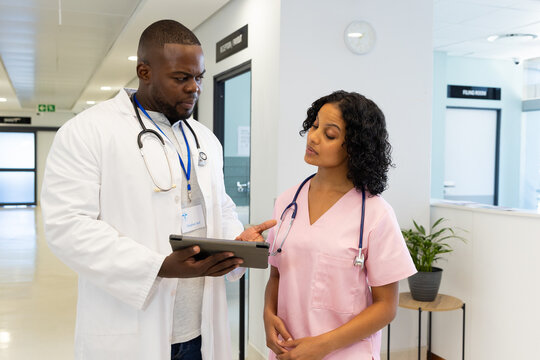 Diverse Male And Female Doctors With Stethoscopes Using Tablet In Hospital