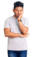 Handsome latin american young man wearing casual tshirt thinking looking tired and bored with depression problems with crossed arms.