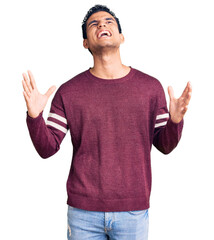 Naklejka premium Hispanic handsome young man wearing casual clothes crazy and mad shouting and yelling with aggressive expression and arms raised. frustration concept.