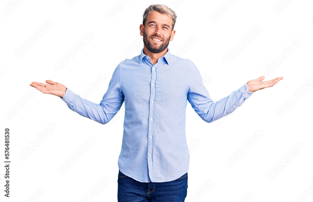 Wall mural young handsome blond man wearing elegant shirt smiling showing both hands open palms, presenting and