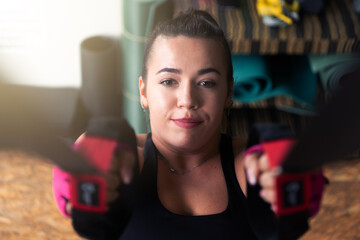 Young beautiful sporty woman is doing exercises in a fitness room. Gym workout