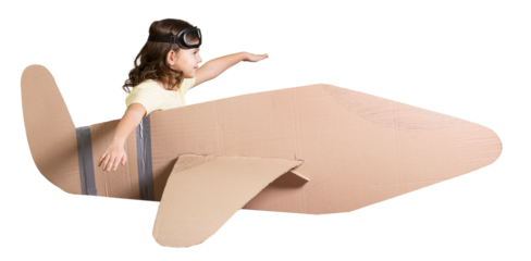 Little dreamer girl playing with a cardboard plane