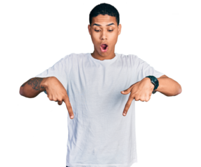 Young hispanic man wearing casual white t shirt pointing down with fingers showing advertisement, surprised face and open mouth
