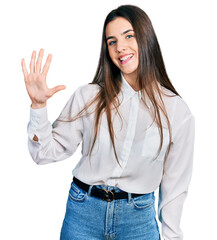 Young brunette teenager wearing business white shirt showing and pointing up with fingers number five while smiling confident and happy.