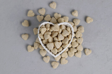 Top view of bran in a bowl with a heart shape on a gray background. Bran in the shape of a heart. Healthy eating