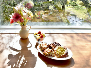 Easter spring brunch breakfast with tasty pastries and bouquet of flowers