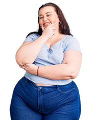 Young plus size woman wearing casual clothes looking confident at the camera smiling with crossed...