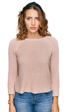 Beautiful young caucasian woman wearing casual sweater relaxed with serious expression on face. simple and natural looking at the camera.