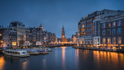 Fototapeta na wymiar Evening panoramic view of the famous historic center with lights, bridges, canals and traditional Dutch houses in Amsterdam, Netherlands