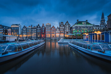 Evening panoramic view of the famous historic center with lights, bridges, canals and traditional Dutch houses in Amsterdam, Netherlands