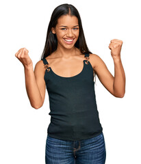 Beautiful hispanic woman wearing casual clothes screaming proud, celebrating victory and success very excited with raised arms