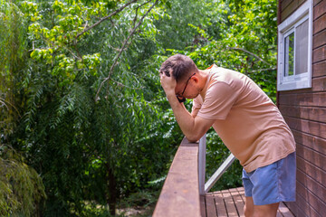 hombre jove, en un balcon realizando una llamada enfadado.