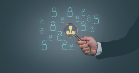 Businessman showing human resources virtual icon or HRM, magnifying glass focus on manager icon, one of employee icons for leadership service, leading organization in recruiting and prospecting.