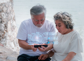 Senior Asian couple using mobile phone watching hologram online health check. Athletic people check app notifications online..