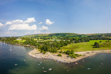 Obraz premium Aerial view of a crowded beach on the shore of a large lake in summer (Ullswater, Lake District, England)