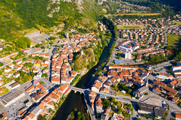General aerial view of small French town of Tarascon-sur-Ariege in valley of Pyrenees on banks of Ariege river on summer day