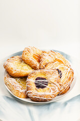 Mouth-watering blueberry, apricot, and apple fruit danish topped with fondant and icing sugar.