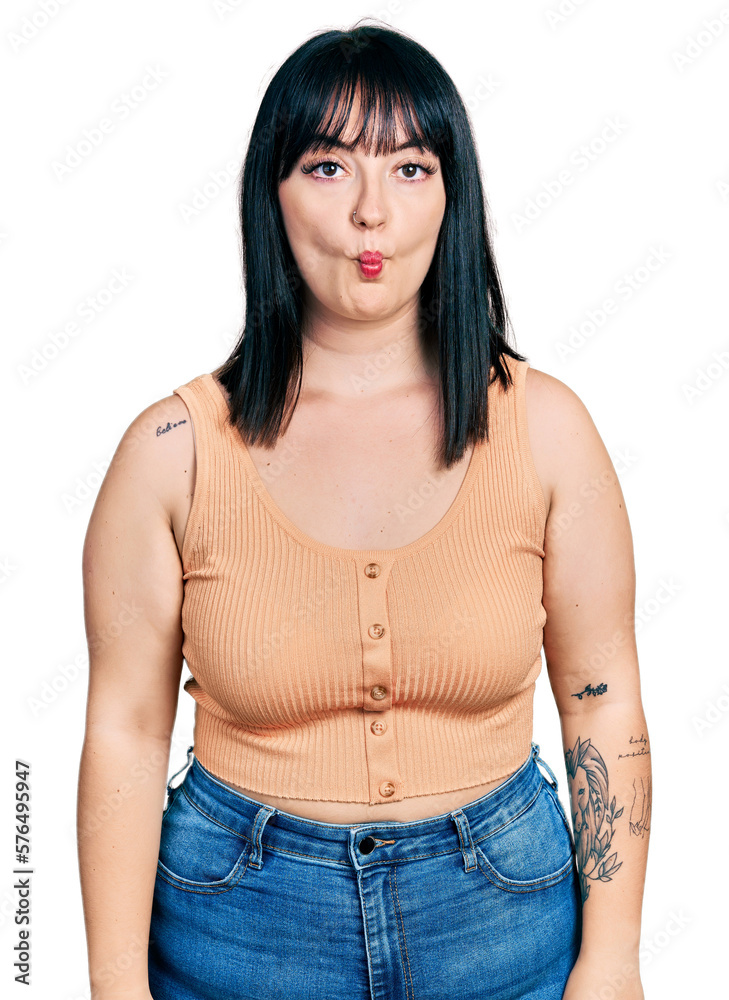 Wall mural Young hispanic plus size woman wearing casual clothes making fish face with lips, crazy and comical gesture. funny expression.