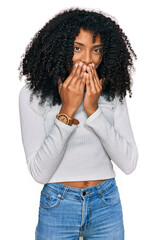 Young african american girl wearing casual clothes laughing and embarrassed giggle covering mouth...