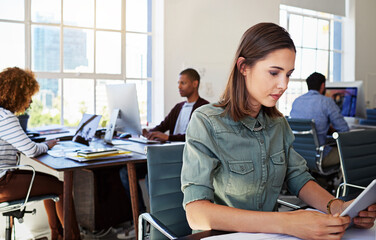 Woman, reading tablet and focus in office at web design startup with ideas, planning and job...