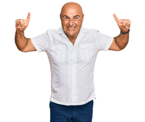 Mature middle east man with mustache wearing casual white shirt smiling amazed and surprised and pointing up with fingers and raised arms.
