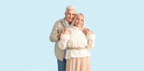 Portrait of happy elderly couple on light background