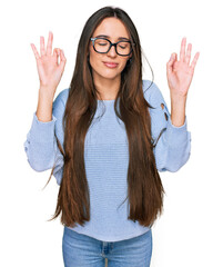 Young hispanic girl wearing casual clothes and glasses relax and smiling with eyes closed doing meditation gesture with fingers. yoga concept.