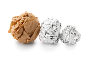 Crumpled balls of aluminium foil and baking paper on white background