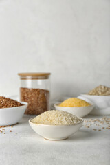 Bowl with rice and different cereals on light background