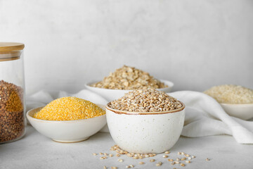 Bowls with cereals on light background