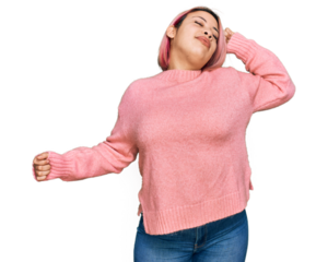 Hispanic woman with pink hair wearing casual winter sweater stretching back, tired and relaxed, sleepy and yawning for early morning