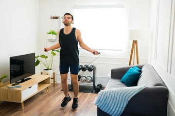 Fitness young man jumping rope at home