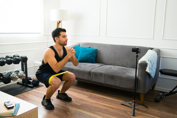 Fototapeta premium Young man and blogger filming a workout video